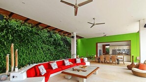 Uma sala de estar moderna com um sofá vermelho, uma mesa de centro e uma parede verde.