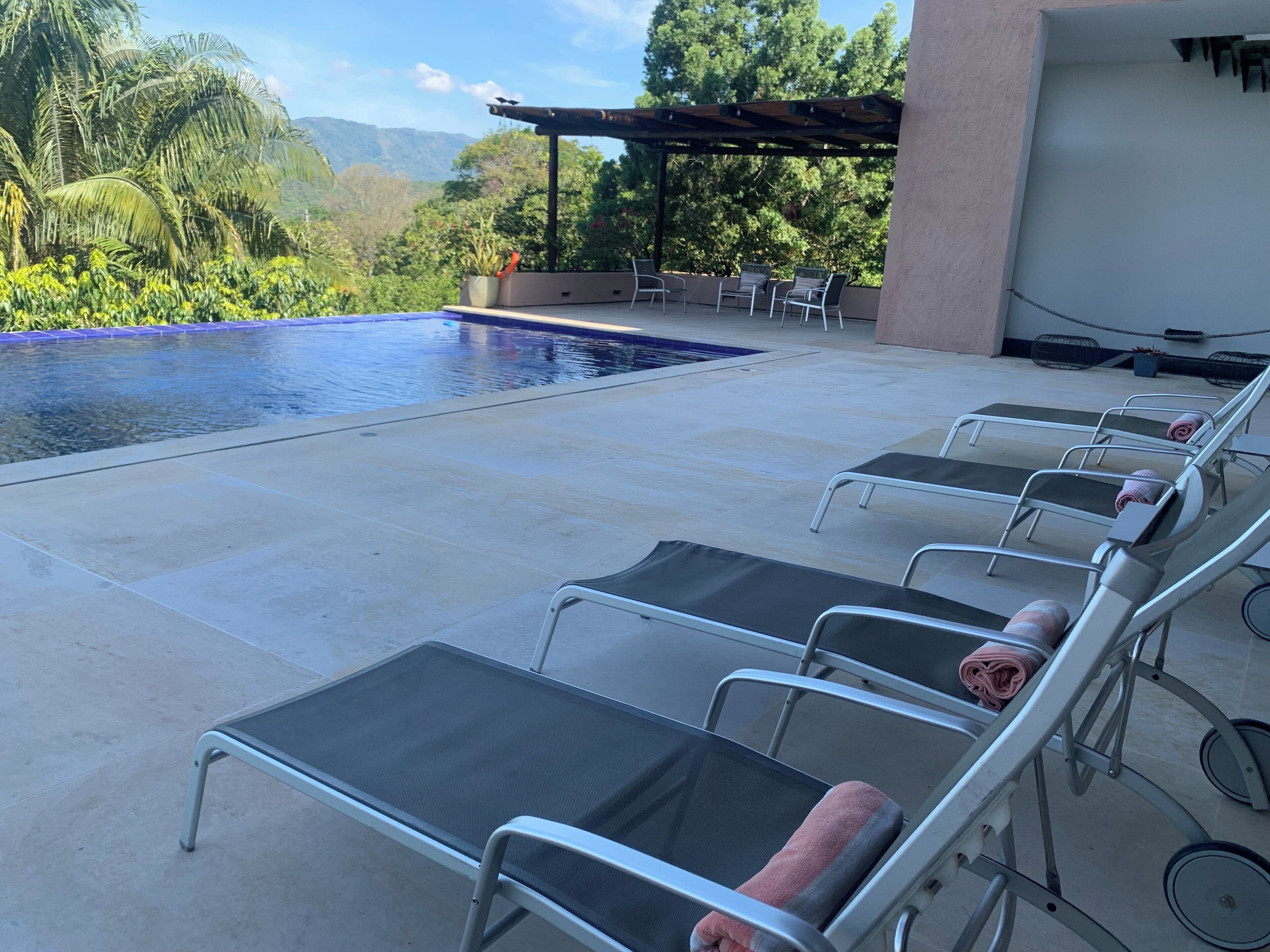 A poolside area with lounge chairs and a pergola.