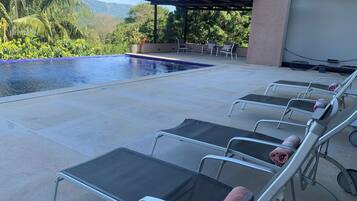 A poolside area with lounge chairs and a pergola.