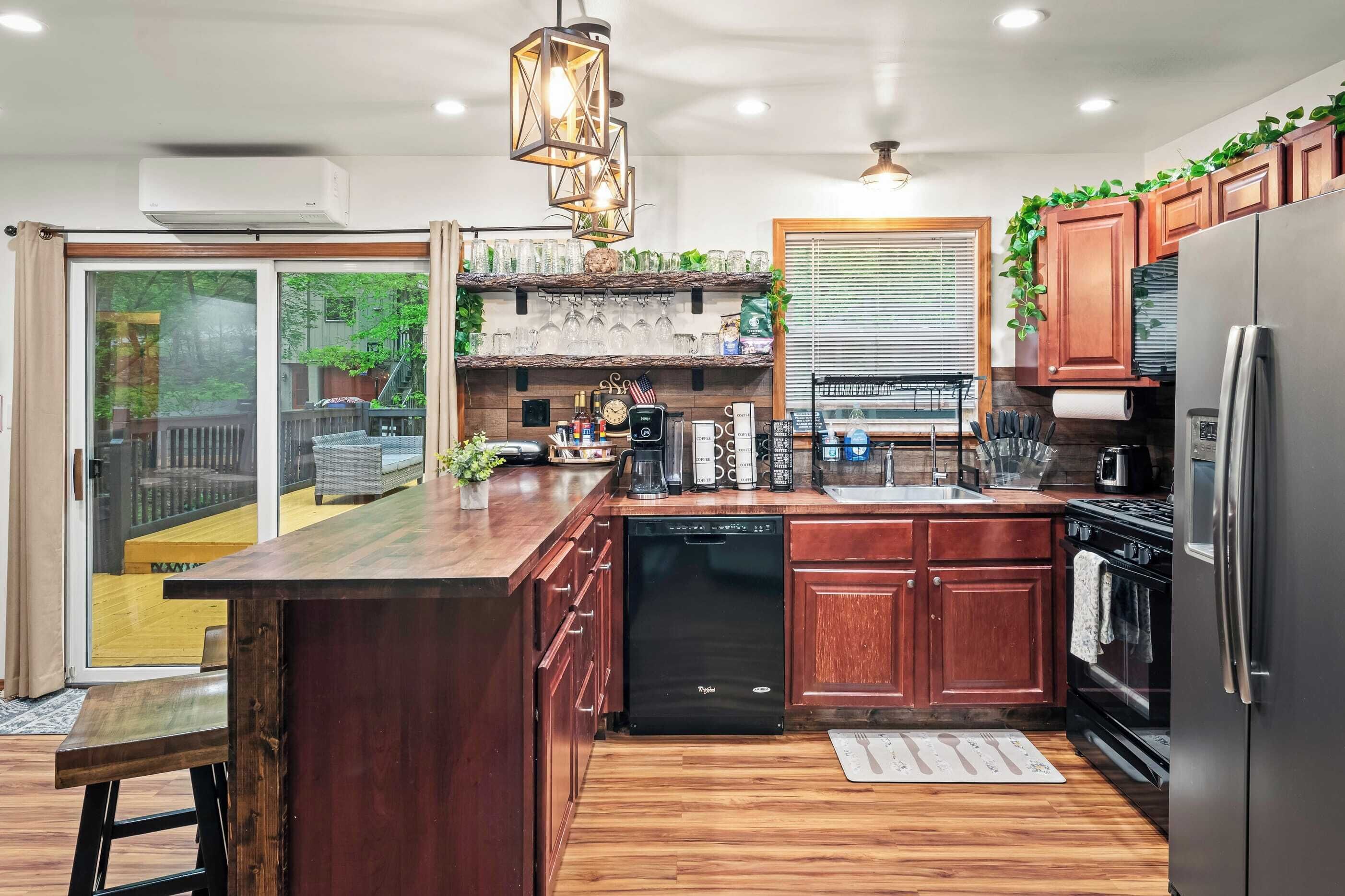 Una cocina moderna con armarios de madera, lavavajillas integrado y refrigerador de acero inoxidable.