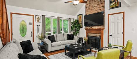 A living room with a fireplace, a sofa, a coffee table, and a television.