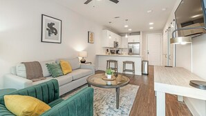 A modern apartment with a living room, kitchen, and dining area.