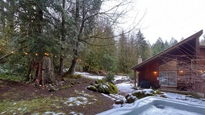 Une cabane avec un bain à remous, située dans une zone boisée.