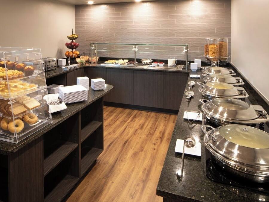 Una barra de buffet con diversos alimentos y utensilios.