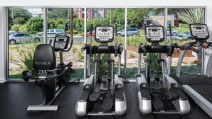 A gym with treadmills, a stationary bike, and a rowing machine. - Landing | Amazing 2BD, Gym, Pool (Austin)