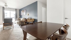 A modern living room with a dining table, a sofa, a chair, and a desk. - Landing | Beautiful 1BD, Pool, Gym (Austin)