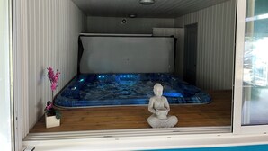 Una habitación con un jacuzzi, una estatua y un ventanal.