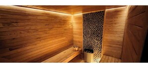 Un sauna aux murs en bois, dont une partie est décorée d’un motif.