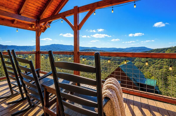 A wooden deck with chairs and a view of a mountainous landscape. - OMG VIEWS! Gameroom~Hot tub~Outdoor Pool~ Suana (Sevierville)