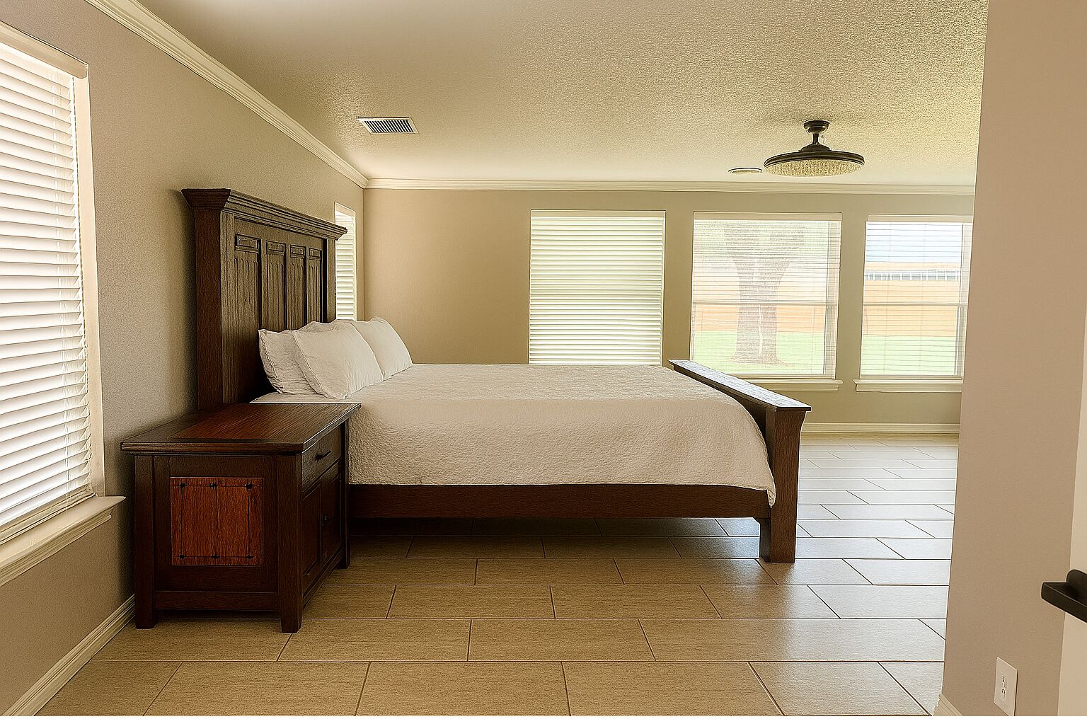 Quarto com cama de madeira, mesa de cabeceira e ventoinha no teto.