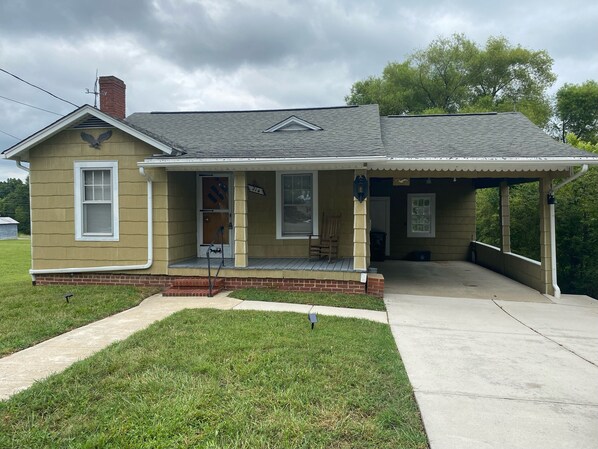 A single-story house with a front porch, a chimney, and a garage door. - Cozy & Convenient Home Across from Thomasville Hospital (Thomasville)