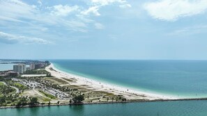 A coastal cityscape with a wide beach, a marina, and high-rise buildings. - Beachfront Condo w/ Pool & Balcony Sunset Views (Clearwater)