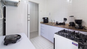A kitchen with white cabinets, a gas stove, a coffee maker, and a microwave. - Comfort 6 Minutes From Copacabana Beach Br801 (Rio de Janeiro)