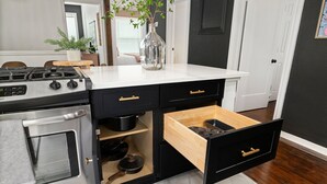 A kitchen with a built-in stove, black cabinetry, and a wooden countertop. - Gothic Girl Stylish Upstairs Nook Near Shops & A&M (Bryan)