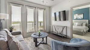 Ein modernes Wohnzimmer mit einer Couch, einem runden Couchtisch und einem an der Wand montierten Fernseher.