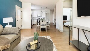 Una sala moderna con un sofá, una mesa baja con un cactus y un mueble para televisor.