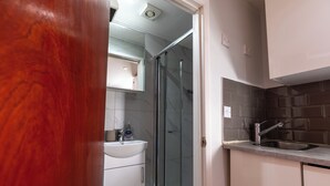 Une salle de bain moderne avec une douche en verre, un lavabo et un miroir.