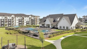 Um complexo residencial com piscina, espreguiçadeiras e área de churrasco.