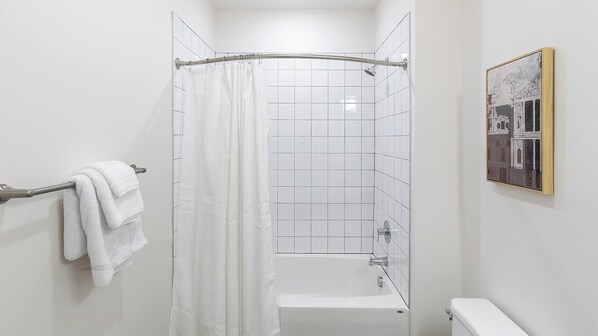 A bathroom with a shower, a bathtub, and a toilet.