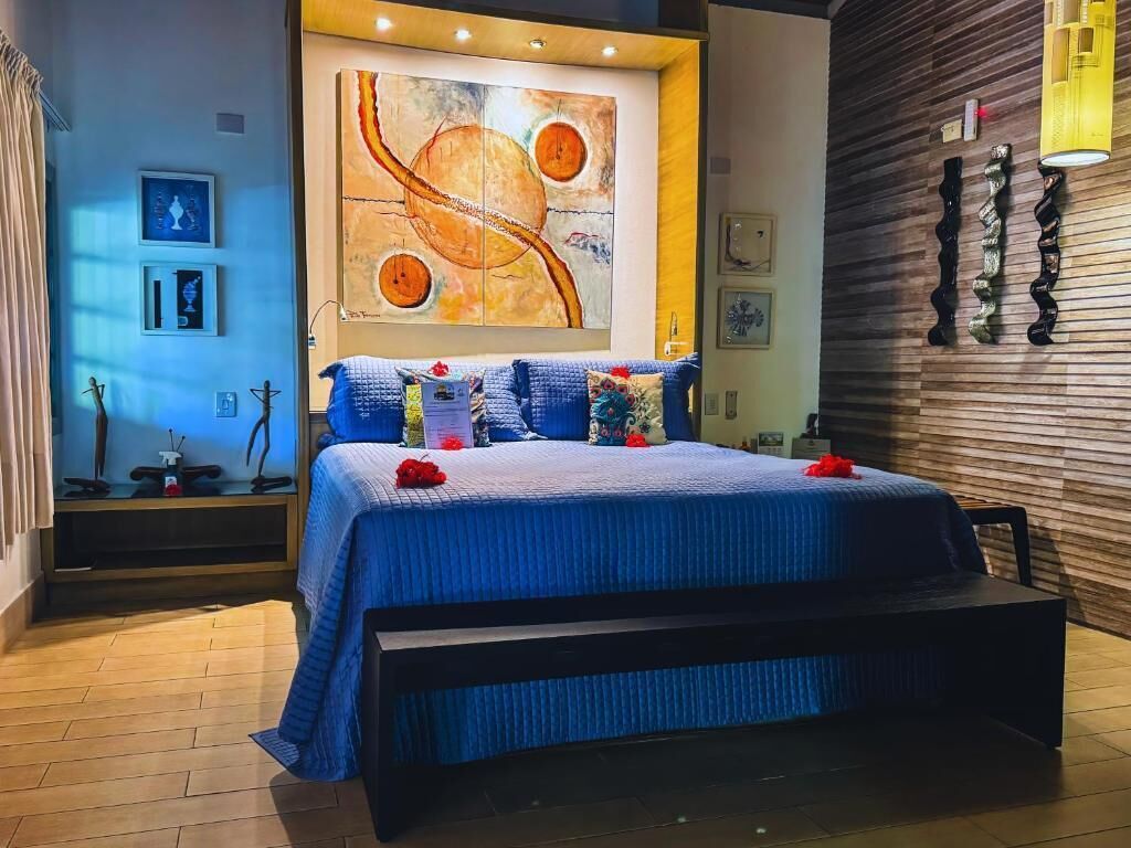 Um quarto moderno com uma cama grande, uma parede de madeira e uma pintura sobre a cama.