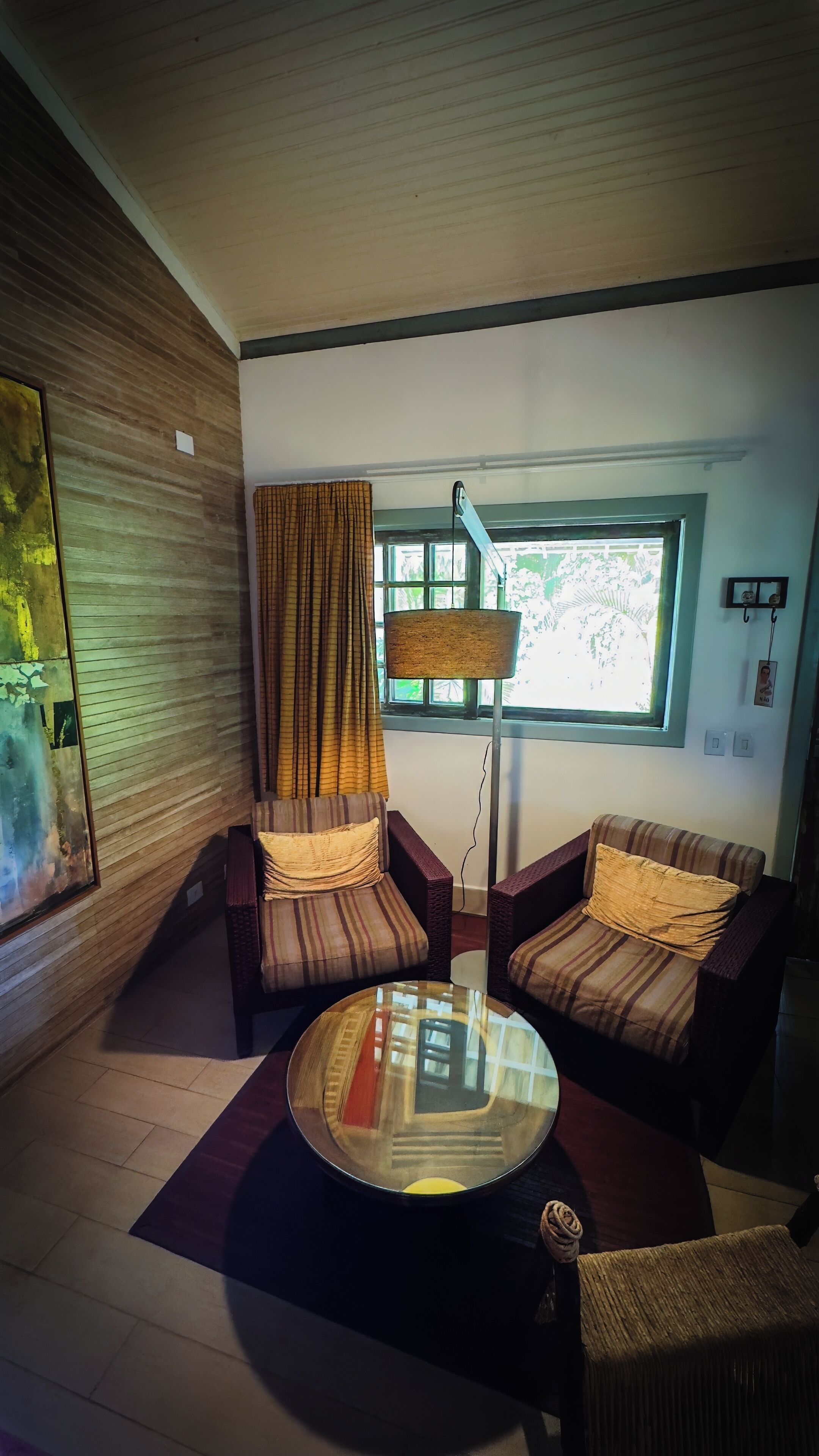 A modern living room with two sofas, a round coffee table, and a large window with curtains.