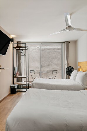 A hotel room with a bed, a TV, a ceiling fan, a window with curtains, and a table with chairs. - Ezequiel Montes By Homirent (Queretaro)
