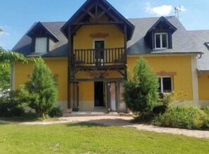 A two-story house with a balcony and a small porch.