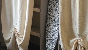 A room with beige curtains, a patterned ironing board, and a tiled floor. - Villa with private heated pool in Normandy (Treis-Sants-en-Ouche)