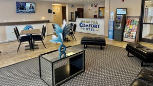 Una hall d'albergo con reception, area salotto e bancomat.