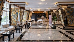 A spacious lobby with marble flooring, a grand piano, and modern seating arrangements. - Innab Inn  (Baku)