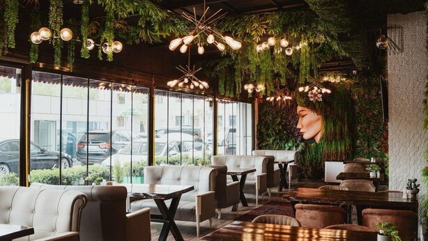 A modern interior with leather seating, wooden tables, and hanging lights. - Innab Inn  (Baku)
