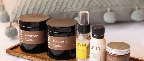 A wooden tray with various L'ININ skincare products, including a chocolate body scrub, a repellent, a sunscreen, and a exfoliating cream.