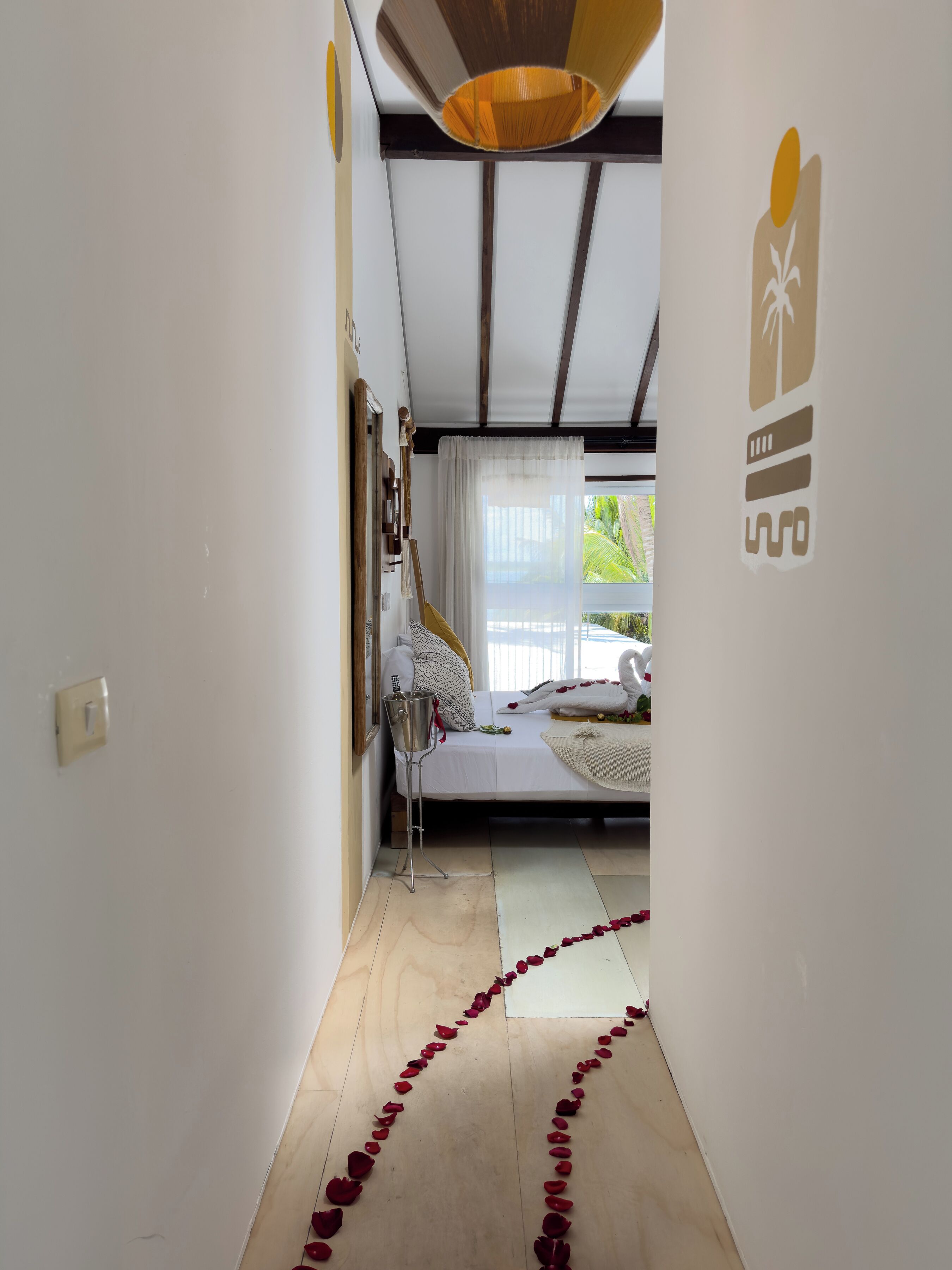 A bedroom with a bed, a nightstand, a lamp, and a window with curtains.