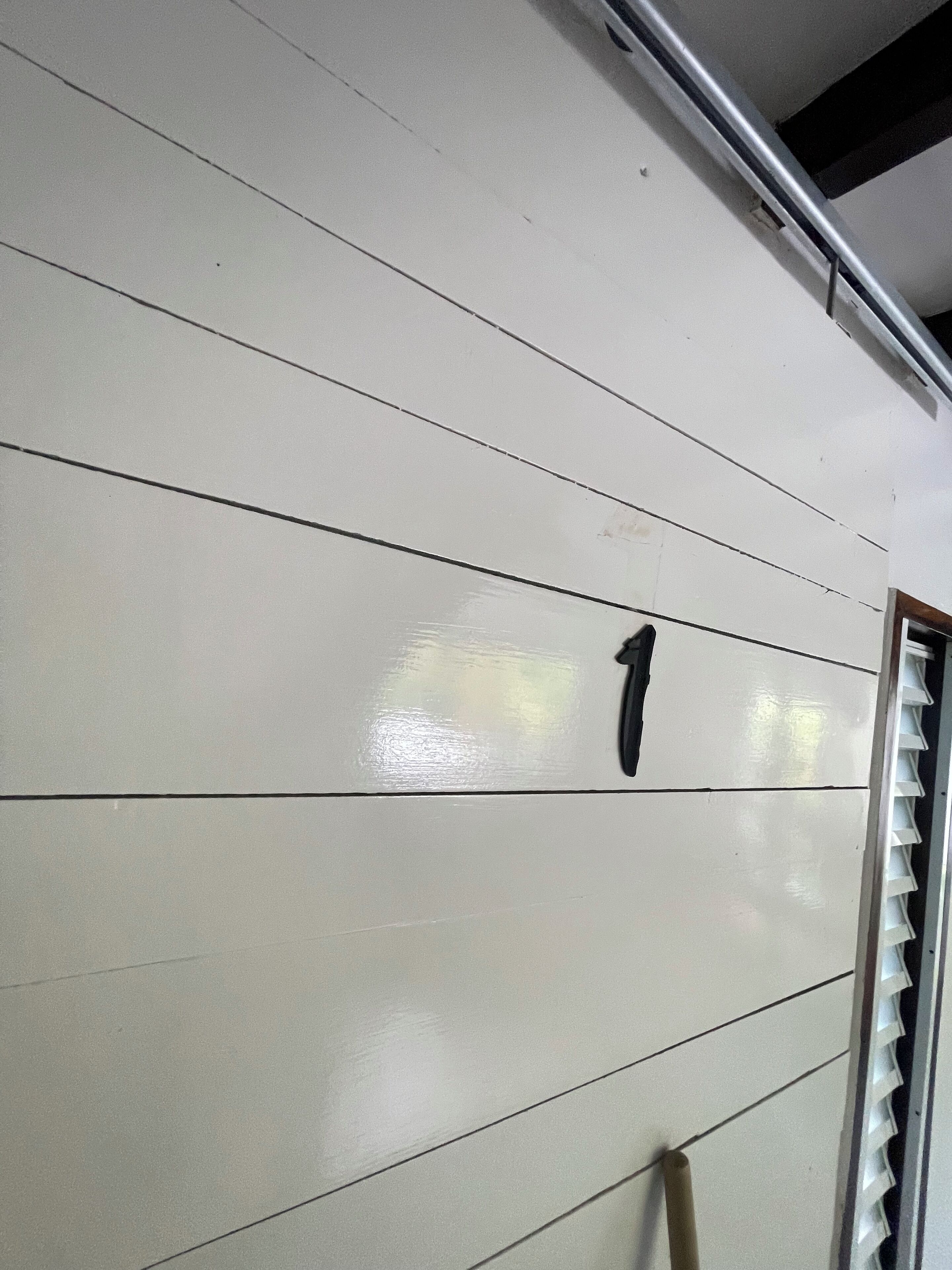 Eine Wand mit horizontalen Linien und der Zahl '1', die einen Raum oder Bereich kennzeichnet.