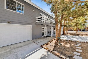 A two-story house with a white garage door, a covered patio, and a stone pathway. - Brewer Escape #609 (Big Bear City)