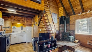 A cozy cabin interior with a kitchen, living area, and fireplace. - Bristlecone Cottage #321 (Big Bear Lake)