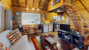 A cozy cabin with a wooden interior, a dining area, a kitchen, and a staircase. - Bristlecone Cottage #321 (Big Bear Lake)