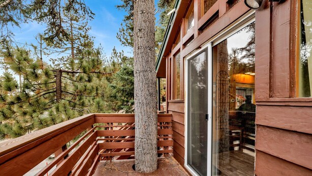 Une terrasse en bois avec une porte vitrée donnant sur une pièce.