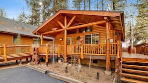 A wooden lodge with a porch, a welcome sign, and a number sign indicating its location. - Craftsman Hideaway #630 (Big Bear Lake)