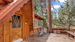 A wooden cabin with a deck, a welcome sign, and a bench. - Idle Ours Cabin #713 (Fawnskin)