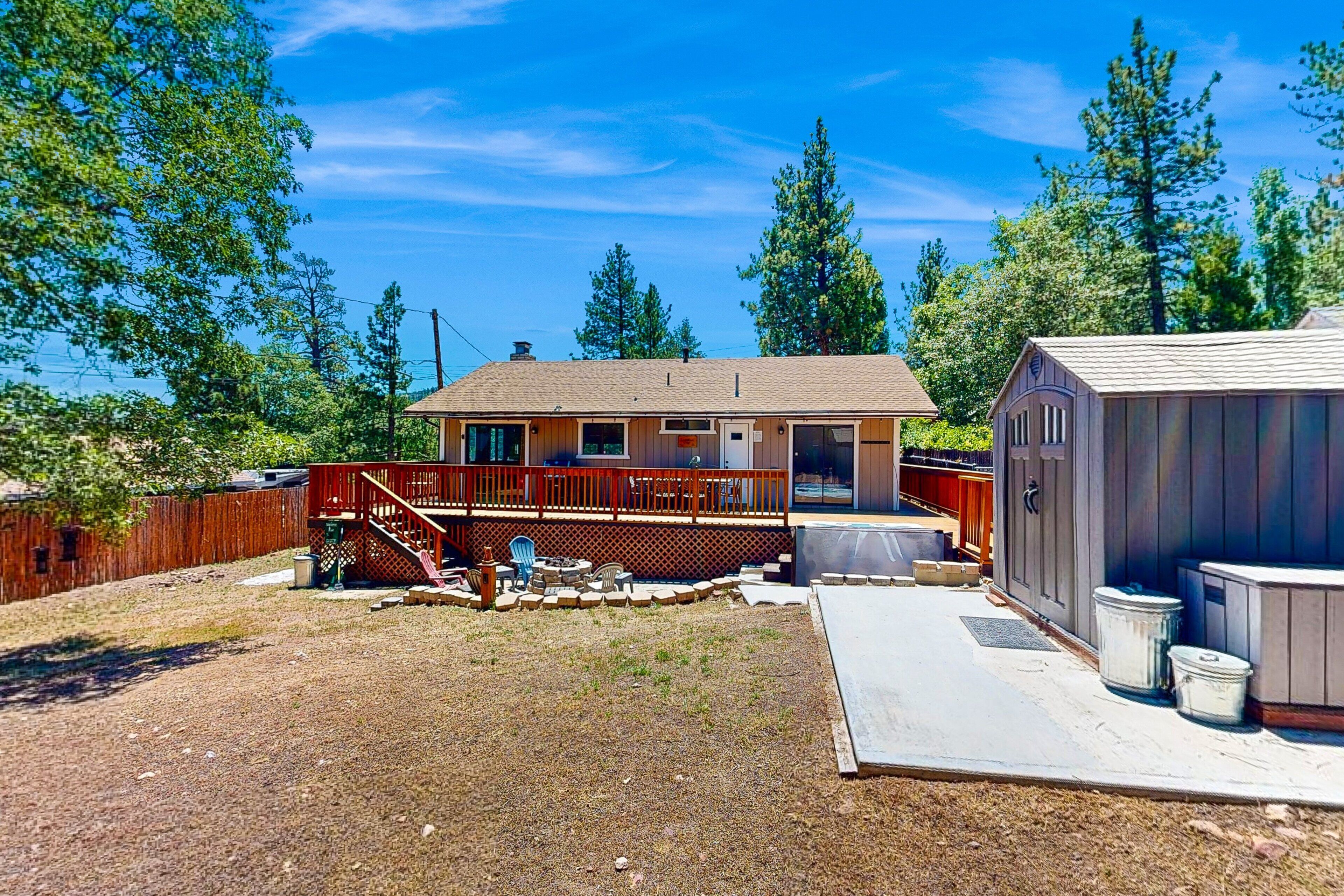 Une maison à deux étages avec un porche couvert et un petit abri de jardin.
