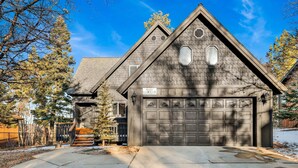 Une maison à deux étages avec un garage, une véranda et une allée.
