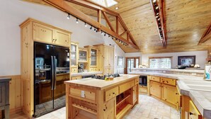 A spacious kitchen with wooden cabinets, a large island, and a skylight.