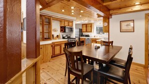 Une cuisine spacieuse avec des meubles en bois, une table à manger et des chaises.