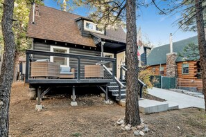 A log cabin with a deck, outdoor seating, and a stone chimney. - The Summit at Sherwood #618 (Big Bear City)