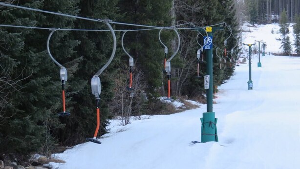 A ski lift with cables and chairs, surrounded by snow and trees. - Lumi | Slope-Side | Pvt Hot Tub | Resort Access (Panorama)