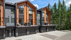 A modern multi-story building with large windows and a flat roof. - Lumi | Slope-Side | Pvt Hot Tub | Resort Access (Panorama)