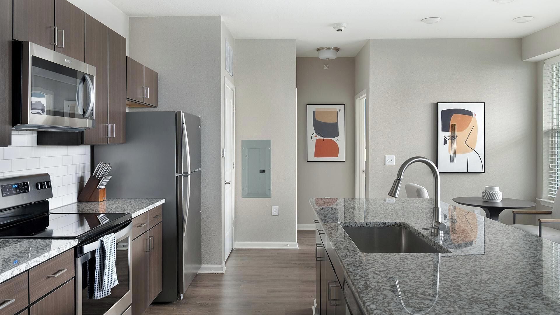 A modern kitchen with granite countertops, stainless steel appliances, and wooden cabinets.