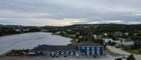 A waterfront hotel with a parking lot and a view of the river.