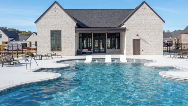 Une piscine avec un bâtiment en pierre en arrière-plan.